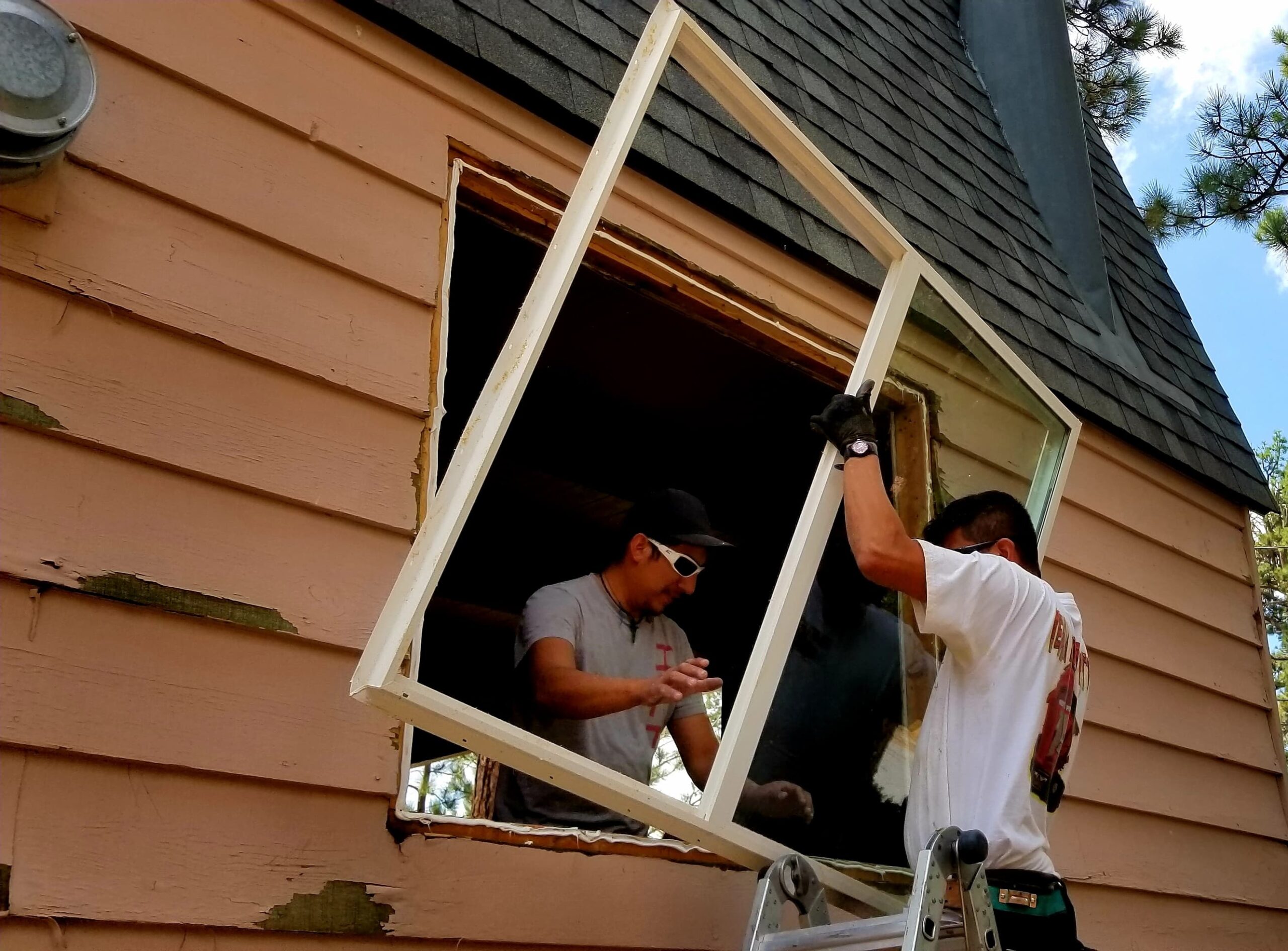 Two siding contractors installing windows in Tulsa